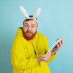 Easter bunny man with bright emotions on blue studio background